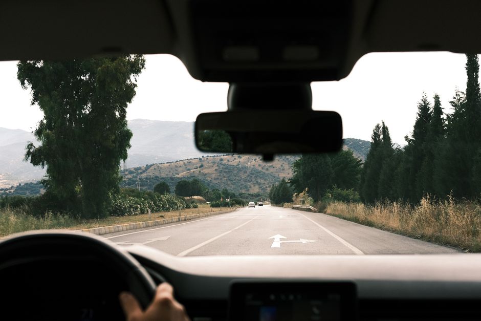 Driver's view through a perfectly clear, newly replaced windshield on a sunny road